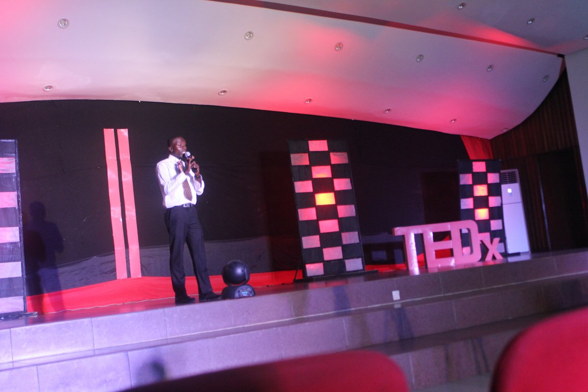 Kwame Ababio on stage giving his TEDx talk.