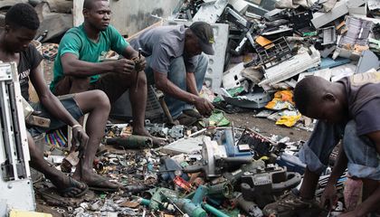 Workers scavenge waste metals at an electronic waste dump
