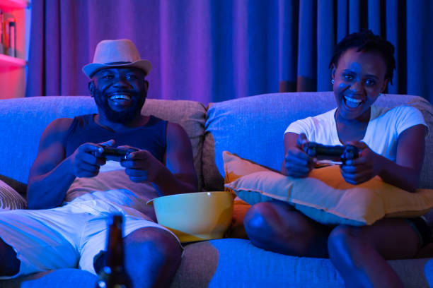 Happy African couple playing video games on console