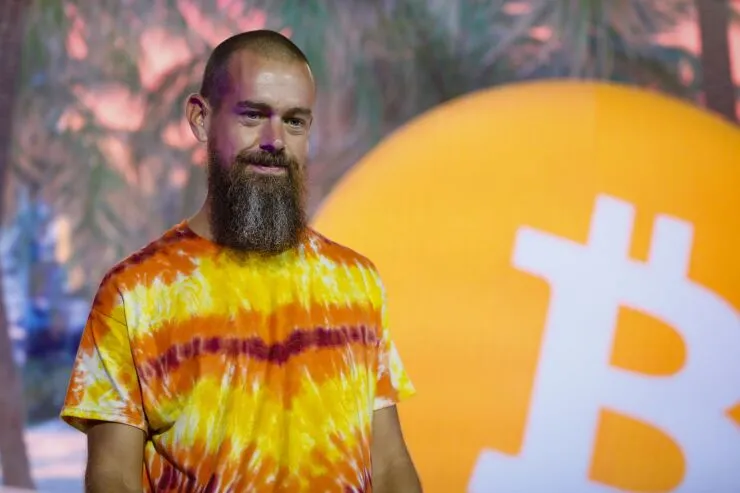 Jack Dorsey standing beside the Bitcoin logo