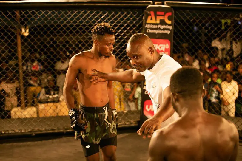 Two mixed-martial arts  fighters being separated by a referee