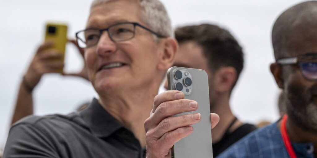 Tim Cook holding the Apple iPhone 15.
