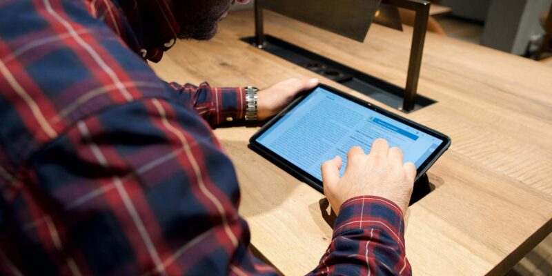 man sitting with tablet on table